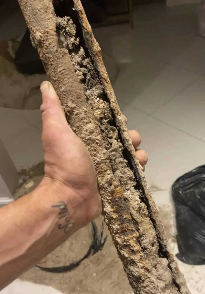 Cut section of old cast iron drain pipe packed with scale and buildup