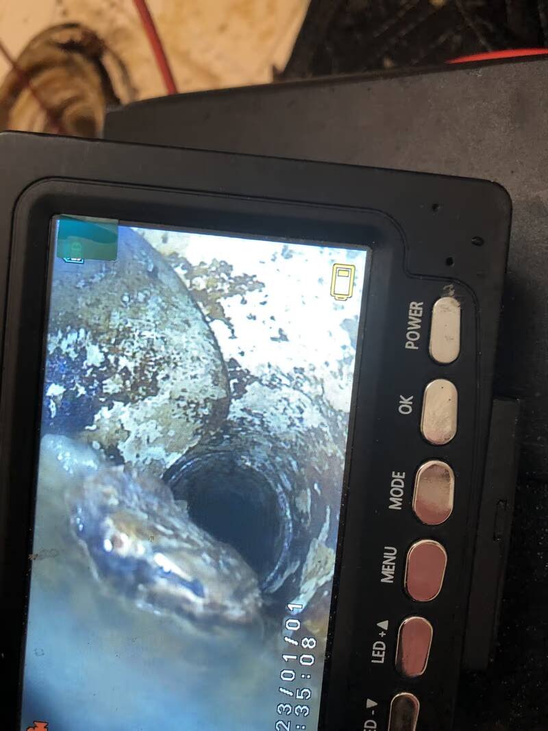 Sewer camera monitor showing the inside of a buried drain pipe during an inspection